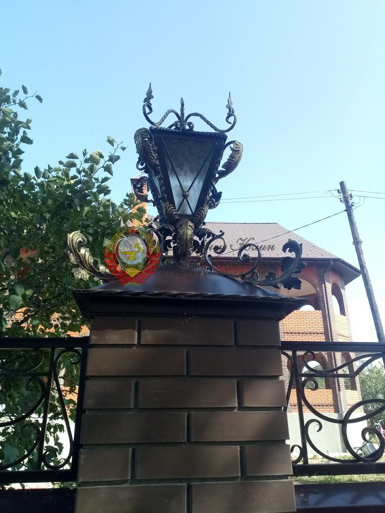 Кирпичный столб в обкладе ковкой