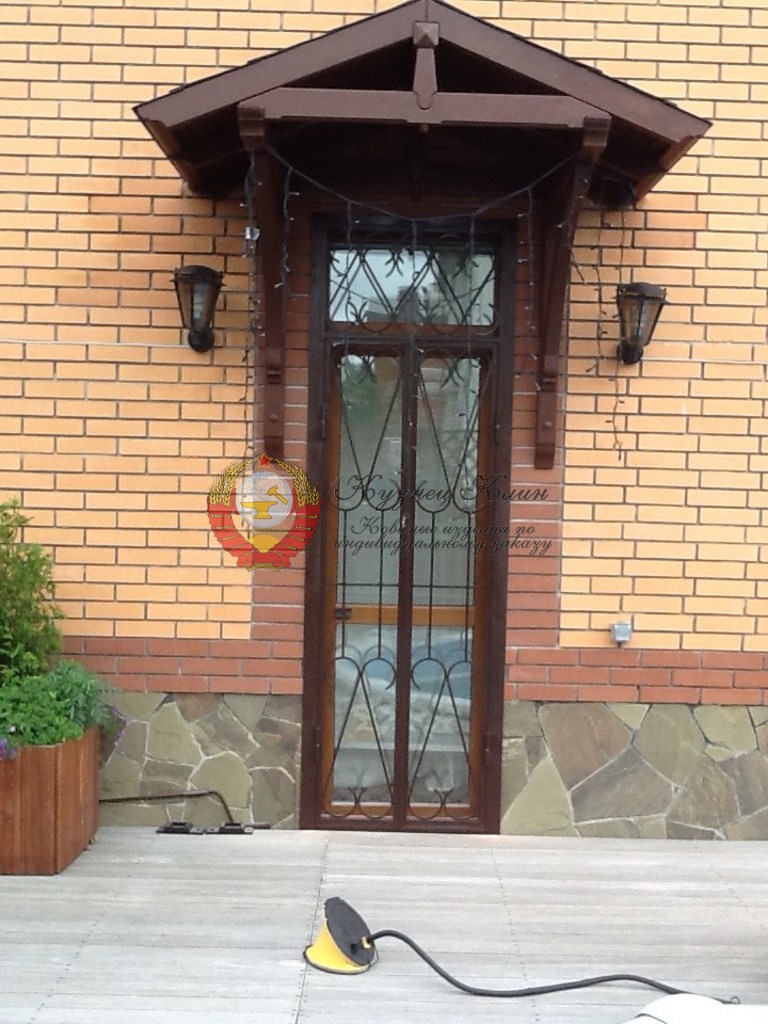 Кованый козырек с деревянным окладом