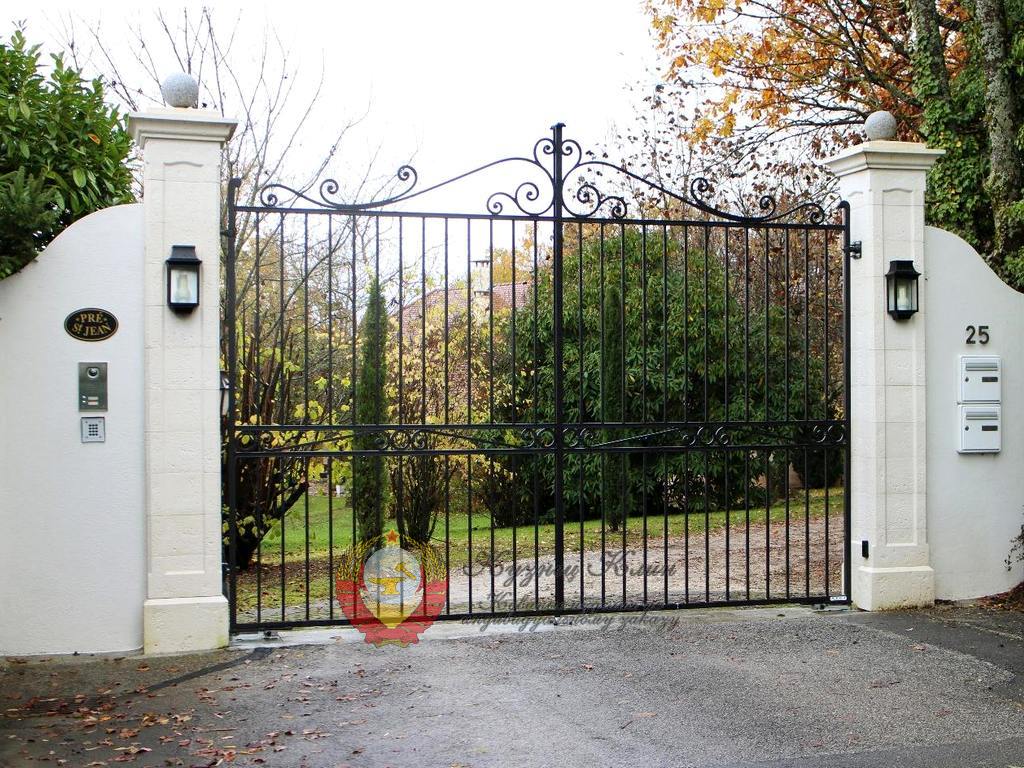 Кованые ворота в бетонном заборе с фонарями